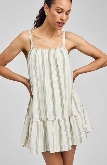 Woman wearing a green and white striped dress on a gray background