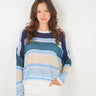 Woman wearing a striped sweater against a plain background