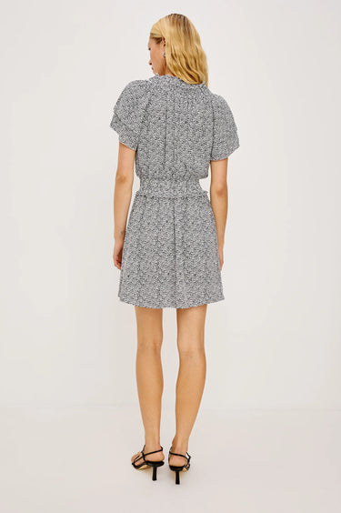 Woman wearing a gray patterned dress on a white background