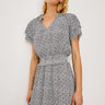 Woman wearing a black and white patterned dress on a white background