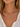 a woman wearing a horizontal gold cross necklace