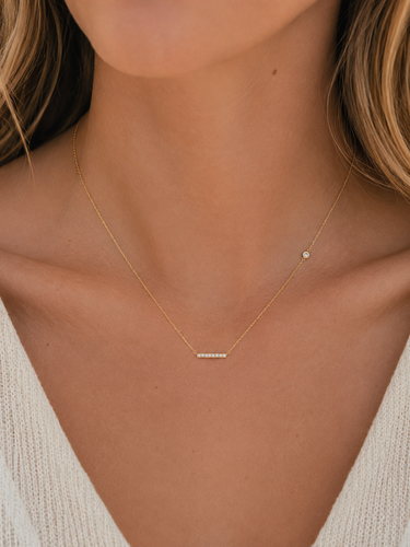 a woman wearing a dainty CZ bar necklace with a CZ stone accent