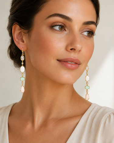 A woman wearing 4 stone drop earrings