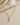 a close up of the pearl cross necklace on a flat surface