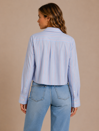 Woman wearing a light blue striped shirt and jeans on a beige background