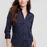 Woman wearing a navy blue shirt with a plain background