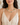 A woman wearing a pastel beaded necklace with round beads in mint green, yellow, pink, and white, paired with a cream floral camisole top.