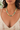 A close-up of a woman wearing a beaded necklace with pastel green, yellow, white, and pink beads, paired with a cream floral top.