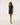 Woman wearing a mesh cover up black dress on a white background
