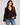 A textured black dot sheer chocolate blouse with blousy sleeves and blue jeans.