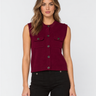 A woman modeling a sleeveless cropped vest in deep burgundy with dark buttons and flap chest pockets, paired with black pants, against a light gray studio background.
