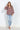 Multicolor abstract print V-neck blouse with long sleeves and button cuffs, styled with light-wash jeans on a model.