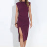 A woman wearing a plum sleeveless ruched midi dress with a draped neckline and thigh-high side slit, styled with neutral heels.