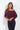 Plum off-the-shoulder three-quarter sleeve top with a relaxed draped fit, styled with dark wash jeans on a model.
