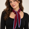 a woman wearing a purple cashmere knit scarf with blue outer stitching.