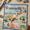 A square fabric map-style print bandanafeaturing illustrated landmarks and routes across the United States, laid flat on a beige surface with a cream blanket, small photo card, and other props around it.