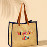 Woven tote bag with 'Vitamin Sea' text on a beige background