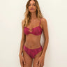 Woman wearing a pink swimsuit set against a white background