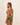 Woman wearing a green bikini set on a beige background