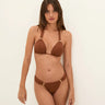 Woman wearing a brown bikini against a white background