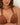 Brown bikini top worn by a woman against a neutral background