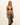 Woman wearing a black bikini top and leopard print sarong on a beige background