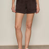 Person wearing black shorts on a plain background