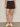 Person wearing black shorts on a plain background