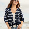 Woman wearing a navy and white striped cardigan on a beach