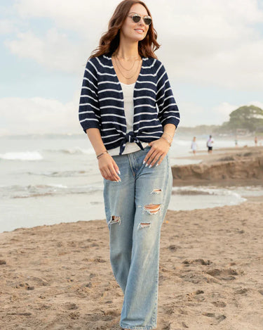 Woman wearing a striped sweater and jeans on a beach
