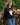 A woman wearing a black knit sweater with a ghost wearing orange heart sunglasses