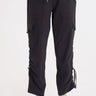 A woman wearing black cargo pants with a cinched detailing on the side of the leg panel.