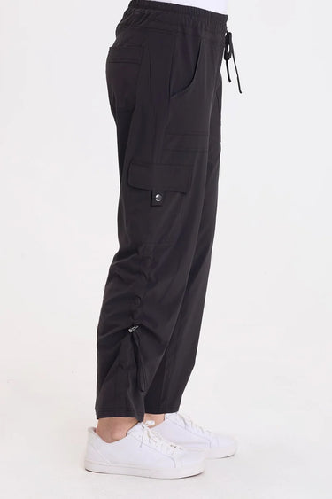 A woman wearing black cargo pants with a cinched detailing on the side of the leg panel.