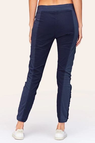 Navy blue jogger pants worn by a person on a white background