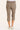 A person shown from the back wearing taupe cropped pants and white sneakers against a plain light background.