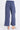 A close up at the back of the blue twill cargo pants, which has two pockets on the posterior and the pants go to about ankle length.