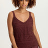 Woman wearing a brown crochet top and skirt on a white background