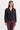 A woman wearing a black active jacket and berry pants on a whit background