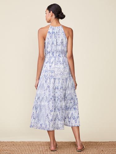 Woman wearing a blue floral dress on a beige background