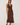 Woman wearing a brown sleeveless dress against a white background