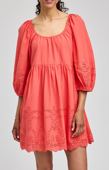 Coral dress with lace details on a plain background