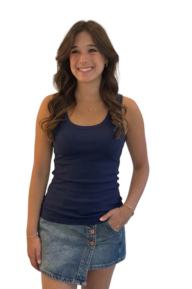 Woman wearing a navy tank top and denim skirt on a white background