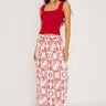 Woman wearing a red top and patterned skirt on a white background