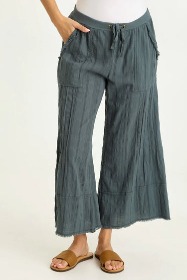 Green wide-leg pants worn by a person on a white background