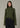 Woman wearing a green turtleneck sweater against a neutral background