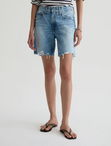 Person wearing light blue denim shorts on a white background