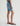 Person wearing a denim shorts on a plain background