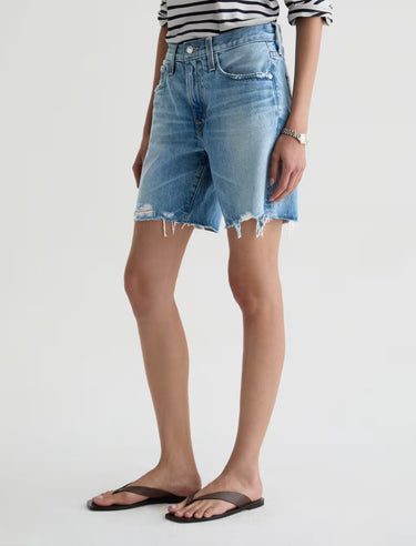 Person wearing blue denim shorts on a white background