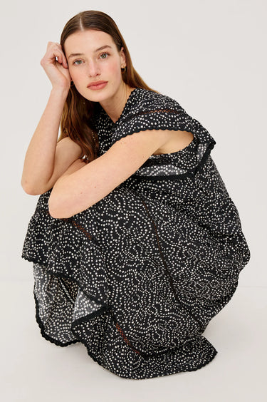 Woman wearing a black and white patterned dress on a white background
