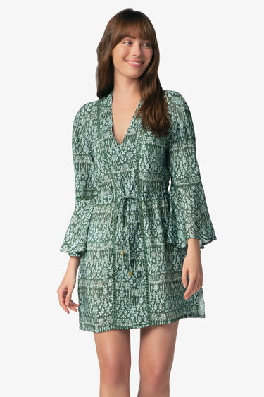 woman wearing green floral dress with a white background
